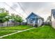 Exterior view of a blue house with a backyard, showcasing a wooden deck and well-maintained lawn at 3764 Ruckle St, Indianapolis, IN 46205
