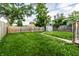 Spacious backyard with lush green grass, a wooden fence, and a storage shed at 3764 Ruckle St, Indianapolis, IN 46205