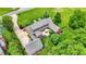 Aerial view of a brick home with a patio, hot tub, lush landscaping, and ample parking space at 4123 S Village Row, New Palestine, IN 46163
