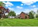 A spacious backyard with a lush green lawn, beautiful trees and grass at 4123 S Village Row, New Palestine, IN 46163