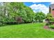 Green backyard with trees, playground, and trampoline at 4123 S Village Row, New Palestine, IN 46163