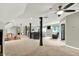 Open concept basement with ceiling fans, TV, comfortable seating, and easy access to adjacent rooms and entertainment spaces at 4123 S Village Row, New Palestine, IN 46163