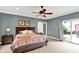 This primary bedroom features a sliding glass door, barn door, and ceiling fan at 4123 S Village Row, New Palestine, IN 46163
