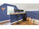 Bonus room featuring dark blue walls, light carpet, a window view, and a desk with multiple monitors at 4123 S Village Row, New Palestine, IN 46163