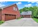 Exterior view of a brick home featuring multiple garage spaces and a wide driveway at 4123 S Village Row, New Palestine, IN 46163