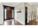 An inviting foyer featuring hardwood floors and a dark wood paneled front door and trim at 4123 S Village Row, New Palestine, IN 46163