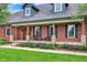 Welcoming front porch featuring brick columns and comfortable seating, perfect for enjoying the outdoors at 4123 S Village Row, New Palestine, IN 46163