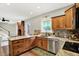 Traditional kitchen featuring wood cabinets, granite countertops, stainless steel appliances, and mosaic backsplash at 4123 S Village Row, New Palestine, IN 46163