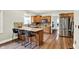 Open kitchen featuring a breakfast bar, hardwood floors, and stainless steel appliances at 4123 S Village Row, New Palestine, IN 46163