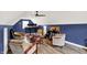 Expansive living room offering bar table, guitars, a ceiling fan, hardwood floors, and ample seating at 4123 S Village Row, New Palestine, IN 46163