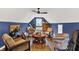 Well lit living room featuring a ceiling fan, wood floors, comfortable seating, bar table, and guitars at 4123 S Village Row, New Palestine, IN 46163