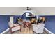 Wide angle view of a living room with bar table, hardwood floors, guitars, ceiling fan, and blue walls at 4123 S Village Row, New Palestine, IN 46163