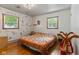 Comfortable bedroom with hardwood floors, two windows, and a unique wall design at 4125 Bowman Ave, Indianapolis, IN 46227