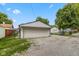 Exterior shot of a detached garage with a white door, gravel driveway, and clear blue sky at 4125 Bowman Ave, Indianapolis, IN 46227