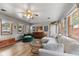 Bright living room featuring hardwood floors, ceiling fan, large windows, and comfortable seating at 4125 Bowman Ave, Indianapolis, IN 46227
