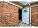 Brick enclosed backyard with open white door and a gravel bed at 423 Bent Tree Ln, Indianapolis, IN 46260