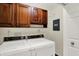 Laundry room with washer and dryer and overhead wood cabinets for storage at 423 Bent Tree Ln, Indianapolis, IN 46260