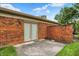 Cozy outdoor patio features red brick walls and sliding glass doors to the interior of the home at 423 Bent Tree Ln, Indianapolis, IN 46260