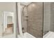 Updated shower featuring grey tile, safety bars, and recessed shelving at 423 Bent Tree Ln, Indianapolis, IN 46260