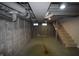 Unfinished basement with painted walls, exposed piping, and a staircase leading to the upper level at 4231 Carrollton Ave, Indianapolis, IN 46205