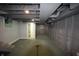 Unfinished basement with painted walls, exposed piping, and a staircase leading to the upper level at 4231 Carrollton Ave, Indianapolis, IN 46205