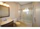 Bathroom featuring a vanity and mirror with a tiled shower and glass doors at 4231 Carrollton Ave, Indianapolis, IN 46205
