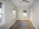 A bright bedroom featuring new gray flooring, fresh paint, and three windows providing natural light at 4231 Carrollton Ave, Indianapolis, IN 46205