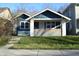 Charming blue house with a well-manicured lawn and inviting front porch in a residential neighborhood at 4231 Carrollton Ave, Indianapolis, IN 46205