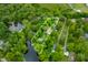 Aerial view of a wooded lot with a defined border, mature trees, home, and lake access at 429 E Hoover Dr, Nineveh, IN 46164