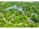 Aerial view of a home surrounded by lush trees and a lake, indicated by a red marker, offering a secluded and private location at 429 E Hoover Dr, Nineveh, IN 46164