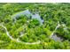 Stunning aerial view of a lake community nestled among dense green trees, offering a serene and picturesque setting at 429 E Hoover Dr, Nineveh, IN 46164