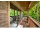 Covered wood deck with chairs overlooks the yard and private creek at 429 E Hoover Dr, Nineveh, IN 46164
