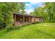 Exterior home view showing a charming porch, well-kept lawn, and mature trees at 429 E Hoover Dr, Nineveh, IN 46164