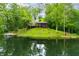 Secluded lake house with a dock and lush green surroundings reflecting beautifully in the calm water at 429 E Hoover Dr, Nineveh, IN 46164