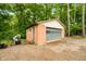 A detached garage with a light blue garage door and ample space for storage and parking at 429 E Hoover Dr, Nineveh, IN 46164