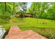 Scenic lake view featuring a private dock and home surrounded by lush greenery, perfect for outdoor enjoyment at 429 E Hoover Dr, Nineveh, IN 46164