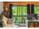 Cozy sitting area with plush cushions, a unique hanging chair, and a sliding glass door showcasing the lush outdoor view at 429 E Hoover Dr, Nineveh, IN 46164