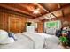 Relaxing main bedroom features wood-paneled walls, wood beam ceiling and carpet for ultimate comfort at 429 E Hoover Dr, Nineveh, IN 46164
