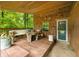 Inviting covered porch featuring wood walls, a rustic table, comfortable seating and an exterior door at 429 E Hoover Dr, Nineveh, IN 46164
