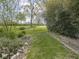 Spacious backyard with mature trees, landscaped borders, and a lush lawn at 4305 Clinton St, Lawrence, IN 46226