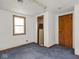 Empty room with a window, closet, and a standard door at 4305 Clinton St, Lawrence, IN 46226