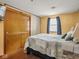 Bedroom with wood paneling, closet, window, and patterned bedspread at 4305 Clinton St, Lawrence, IN 46226