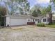 Front exterior featuring a charming one-story home with an attached garage, well-kept lawn, and brick details at 4305 Clinton St, Lawrence, IN 46226