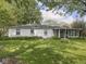 Charming single-story home featuring a screened-in porch and lush greenery surrounding the exterior at 4305 Clinton St, Lawrence, IN 46226