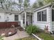 Close up of enclosed front porch with decorative landscaping, wreath and 'bless our home' sign at 4305 Clinton St, Lawrence, IN 46226
