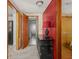 Hallway view showcases a black dresser, red accent wall, and doors leading to other rooms at 4305 Clinton St, Lawrence, IN 46226