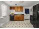 Kitchen with wooden cabinets, black appliances, and a door leading outside at 4305 Clinton St, Lawrence, IN 46226