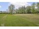 Expansive open land with meticulously manicured grass and mature trees creating a tranquil and picturesque landscape at 4305 Clinton St, Lawrence, IN 46226