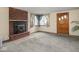 Cozy living room with brick fireplace, large window, and front door at 4305 Clinton St, Lawrence, IN 46226