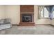 Living room with cozy brick fireplace, neutral carpet, and chair at 4305 Clinton St, Lawrence, IN 46226